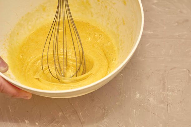 istock a man whips cream in a white cup with a whisk 1410611512