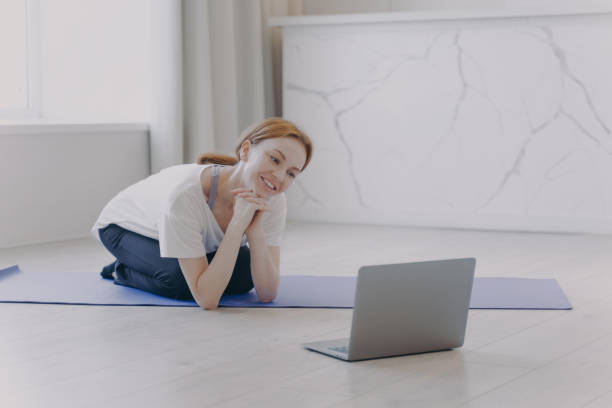 istock Smiling white woman has remote personal training and talking in front of computer. 1410616035