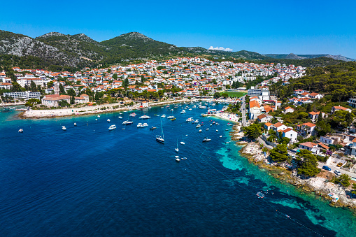 Hvar old town and port on the island of Hvar, part of Split-Dalmatia County, Croatia, seen from a drone point of view during a summer season with many boats and yachts.