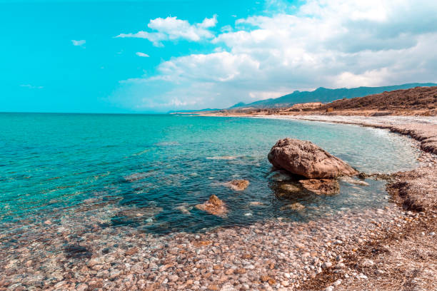 bellissimo paesaggio marino con una spiaggia rocciosa e mare calmo. cipro settentrionale sfondo naturale - karpas foto e immagini stock