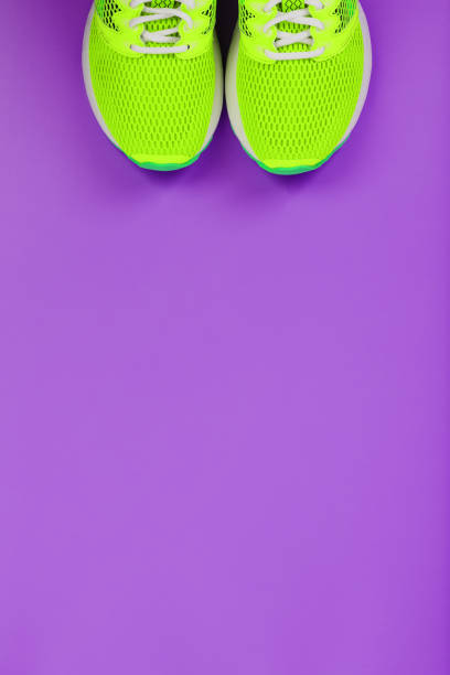 istock Green running shoes on a purple background. 1410625743
