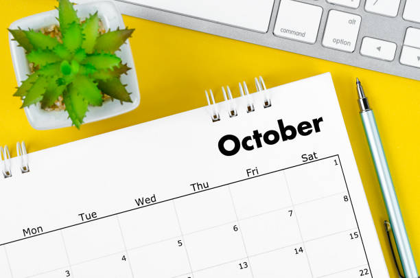 istock The October 2022 desk calendar with pen and keyboard computer on yellow background. 1410626496