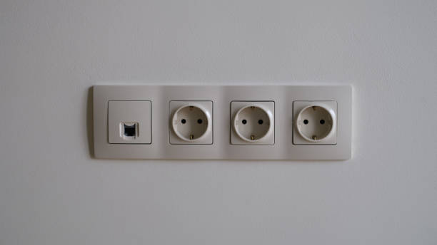 istock Electric socket on white wall closeup. Sockets with antenna cable and internet 1410628303