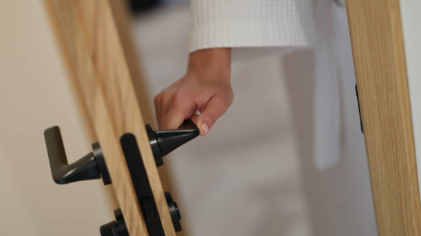 Woman hand in bathrobe opens and closes bathroom door