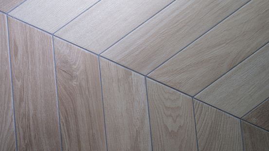 Oak texture of floor with tiles imitating parquet. Traditional herringbone pattern on wooden floor concept