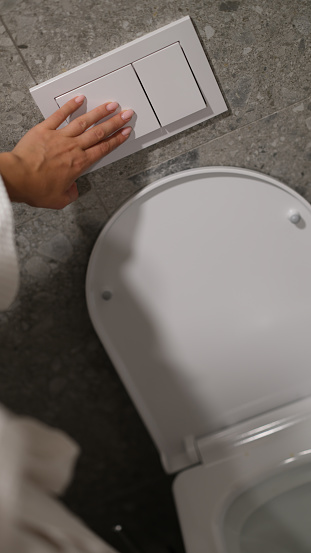 Economical toilet flush button with two separate buttons in white. Double flush toilet bowl concept