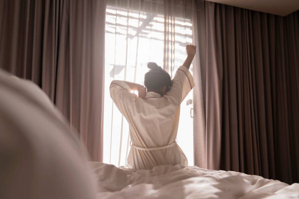 white dress asian female beautiful woman stretching morning wake up freshness and carefree weekend moment in cosy interior bedroom with white curtain and sun shine background lifestyle home concept vestido blanco mujer asiática hermosa mujer que se estira por la mañana despertar frescura y momento de fin de semana sin preocupaciones en acogedor dormitorio interior con cortina blanca y sol brillo de fondo estilo de vida concepto de hogar