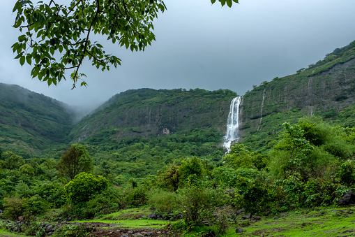 Lush green landscape with waterfalls in full flow during the monsoon season near Pune India. Monsoon is the rainy season in India from June to September.