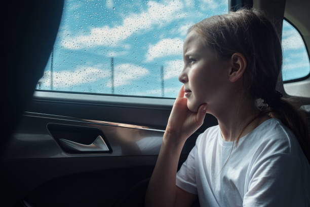 istock Pensive girl sits in car on backseat feeling sadness 1410635396