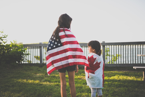 Two inseparable sisters. The big sister is wearing the us flag while the little one has the Canadian flag.