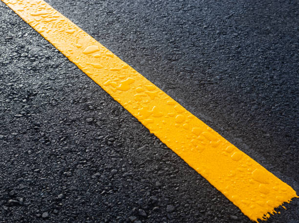 Close-up top view, new yellow stripe symbol texture background, wet with dew drops.
