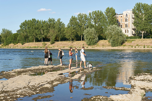 Magdeburg, Germany – July 23, 2022: dried up riverbed of river Elbe near Magdeburg in Germany during big drought with some walkers