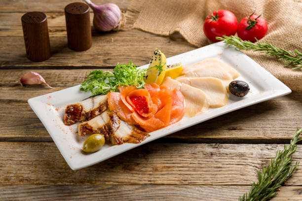different fish slicing on a plate on old wooden table