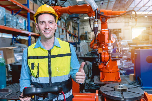 istock Portrait smart engineer man working with advance robotic machine weling in heavy industry. 1410645994