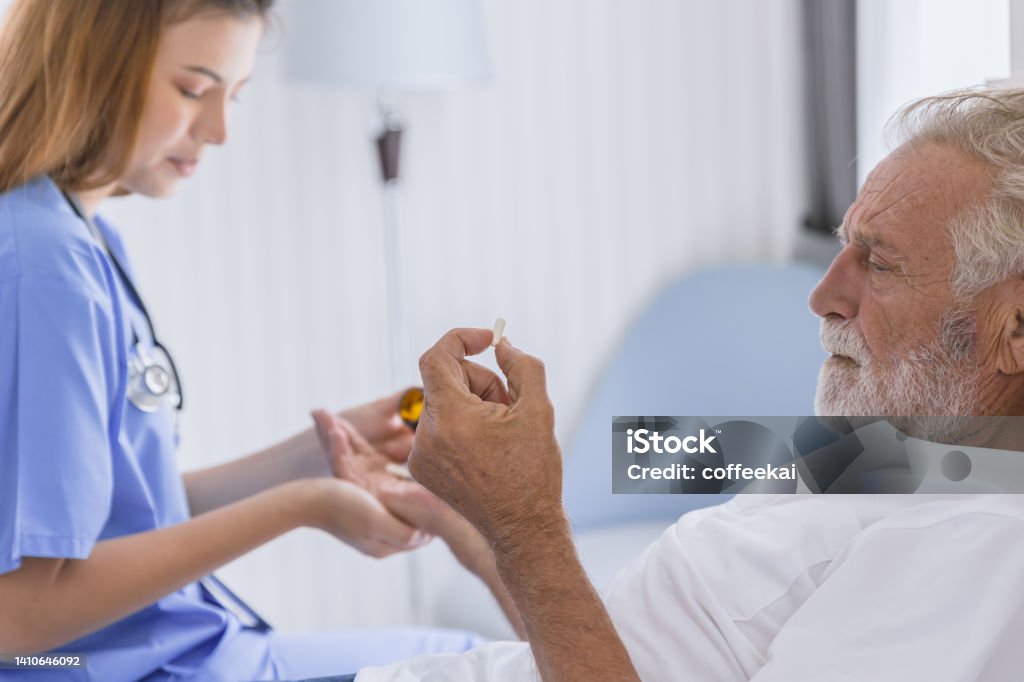 nurse doctor elder healthcare give medicine pill to mental sick stress senior man lay on bed at hospital home care. Nurse Stock Photo