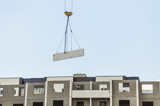 Crane lifts concrete slab. Home construction. Construction