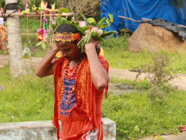 Shravan, commonly called Sawan, is the fourth Hindu month per the Lunar calendar. Dedicated to Lord Shiva, this month marks the beginning of the holy Chaturmas period.The 2022 Kanwar yatra begins on July 14, Thursday. Jal abhishekam is on Sawan shivaratri which falls on July 18. Moreover, the season of regional and pan India festivals,The festivals run during the monsoon month Shraawan (July — August). After taking water from the Ganges river (or other nearby river that wind up in the Ganges) the pilgrims, known as kanwariya or Shiv Bhaktas (disciples of Shiva), are mandated to travel barefooted and in saffron robes with their Kanwar (walking sticks used to hang the urns of water) for 105 km by various routes and usually in groups made of family, friends and or neighbors, and return to their own local or other more prestigious and larger Shiva Temples to pour Gangajal on Lord Shiva (Shiv Linga). On the march pilgrims continuously sprinkle any and all talk with 18 de julio de 2022 - sawan somwar vrat, kanwar yatra, kavaḍ yatra o kawad yatra. grupo de devotos hindúes de esperar cerca del templo local de shiv para realizar el kanwar yatra anual con agua sagrada del ganges para jal abhishekam del señor shivling.