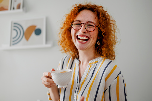 Young ginger woman drinking coffee