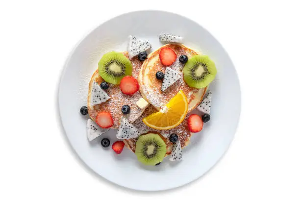 Photo of Top View of fresh pancakes with fruits, on isolated White Background, and have attached clipping path.