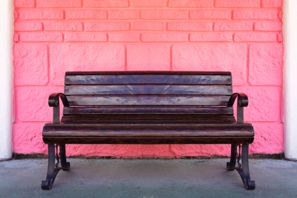 Wooden bench near Pink Brick Stone Wall Background