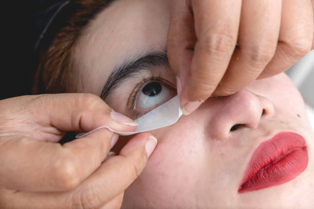 istock A beautician places an eye pad placed just below the lower eyelashes of a client. Preparation of an eyelash extension procedure. 1410652995