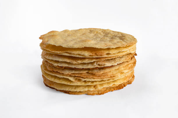 istock Stack of baked cake layers isolated on white. Cooking multilayer cake Napoleon 1410653333