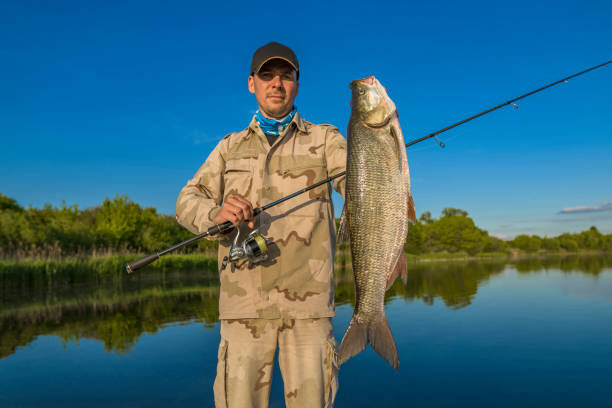 istock Asp fishing. Fisherman with big aspius fish 1410653382