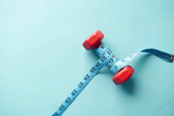 istock Fitness concept with dumbbell and measurement tape on table 1410656554