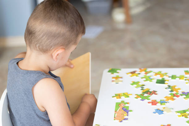 istock Little cute boy playing puzzle at home 1410656842
