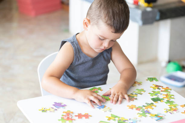 istock Little cute boy playing puzzle at home 1410656846