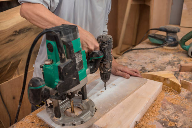 istock Setting up a circle cutting jig attached on a plunge wood router. At a woodworking workshop. 1410658167