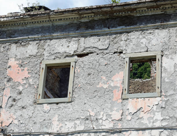 windows without the frames of a completely destroyed house without the roof and abandoned two windows without the frames of a completely destroyed house without the roof and abandoned gemona del friuli stock pictures, royalty-free photos & images