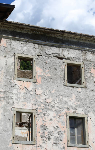 windows without the frames of a completely destroyed house without the roof and abandoned four windows without the frames of a completely destroyed house without the roof and abandoned gemona del friuli stock pictures, royalty-free photos & images