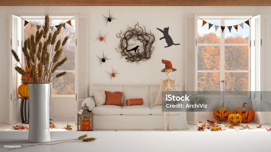 White table top or shelf with straws, dry plants, ornament, ears, sheaf, branch in vase, over Halloween living room with fireplace and autumnal landscape, classic interior design Halloween Stock Photo