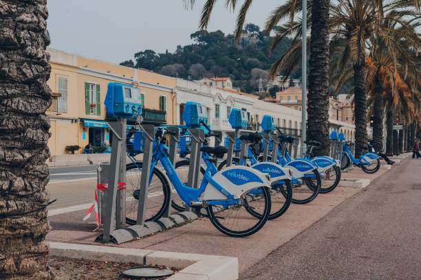 Row of rental Velobleu bikes parked on The Promenade des Anglais in Nice, France. Nice, France - March 11, 2022: Row of rental Velobleu bikes parked on The Promenade des Anglais in Nice, a famous tourist destination on the French Riviera, on a sunny spring day. bicycle docking station stock pictures, royalty-free photos & images