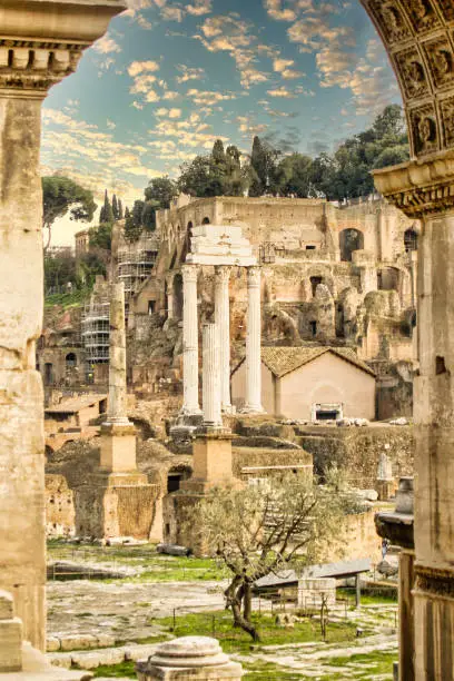A view of the Forum Romanum through arching pillar ruins.
