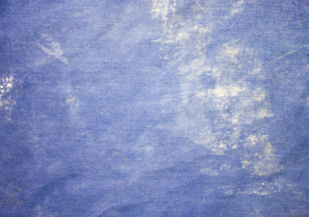 istock Dirty builder work clothes texture. Background of contaminated fabric in cement, concrete, glue. Robe, builder's jacket, soiled clothes. 1410670575