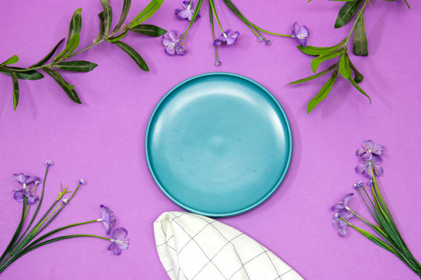 istock empty ceramic blue plate on purple background with beautiful flowers 1410670834