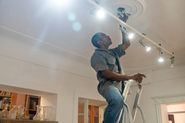 eletricista conserta a fiação de lâmpadas em um quarto da casa - changing lightbulb - fotografias e filmes do acervo