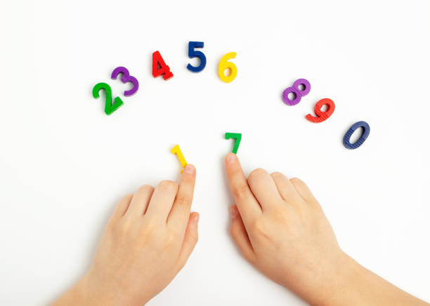 istock Children's hands move numbers on a white table. Learning colors and to count from zero to ten 1410674706