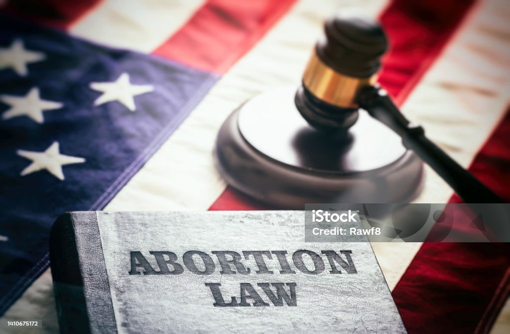 Abortion law in USA concept. Pregnancy termination ban. Judge gavel and Abortion Law book on US flag Abortion law in USA concept. Pregnancy termination ban. Judge gavel and Abortion Law book on US flag, close up view Abortion Stock Photo
