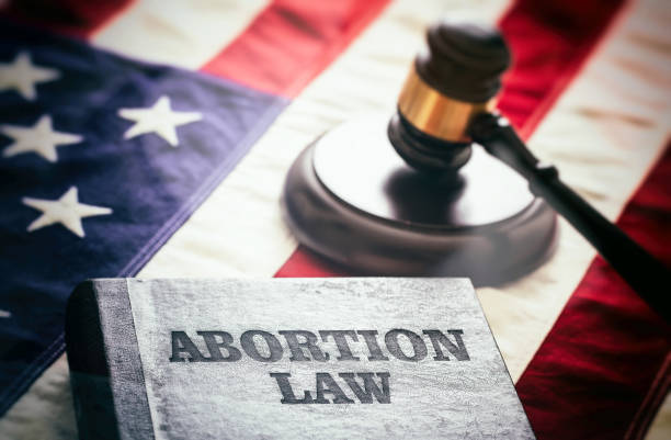 Abortion law in USA concept. Pregnancy termination ban. Judge gavel and Abortion Law book on US flag Abortion law in USA concept. Pregnancy termination ban. Judge gavel and Abortion Law book on US flag, close up view abortion photos stock pictures, royalty-free photos & images