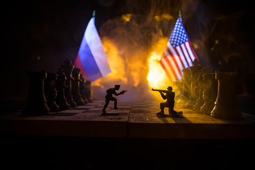 War between Russia and Ukraine, conceptual image of war using chess board, soldiers and national flags on the background of explosion. Ukrainian and Russian crisis. Selective focus