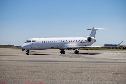 Modern short distance passenger jet airplane, a Bombardier CRJ-900 from the company Cityjet on the tarmac at Copenhagen Airport on a clear summer day