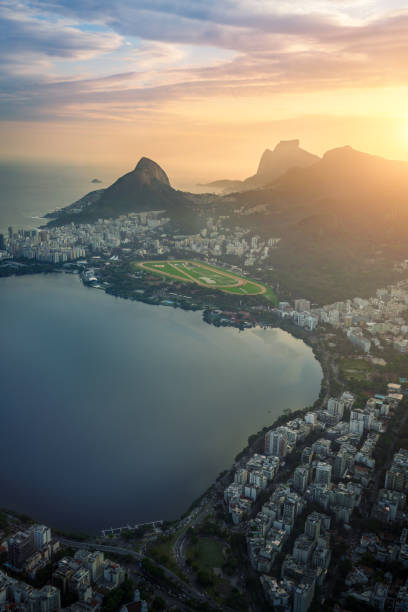 Aerial view of Rodrigo de Freitas Lagoon at Sunset with Dois Irmaos Hill and Pedra da Gavea - Rio de Janeiro, Brazil Aerial view of Rodrigo de Freitas Lagoon at Sunset with Dois Irmaos Hill and Pedra da Gavea - Rio de Janeiro, Brazil two brothers mountain stock pictures, royalty-free photos & images