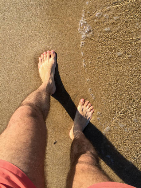 istock Walking on the beach, human foot on the sand with wave 1410683314