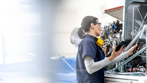 Aero engineer in uniform working in helicopter hangar, side view