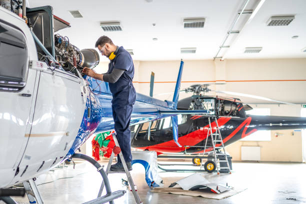 istock Air vehicle mechanic in uniform standing on ladder and examining jet engine, side view 1410686353