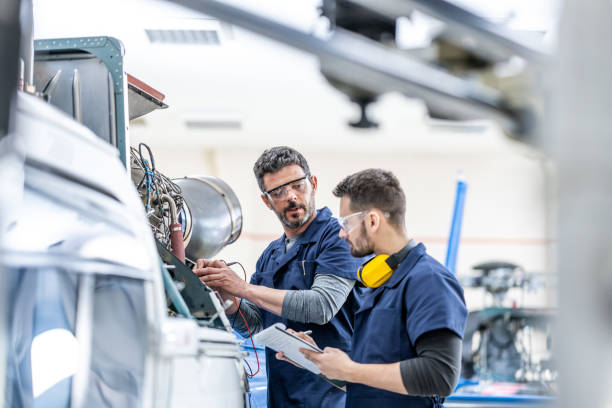 istock Young aviation mechanics studying to repair engine medium shot 1410686369