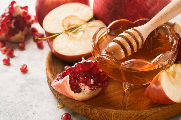 istock Rosh Hashanah. Pomegranate, apples and honey traditional products for celebration on rustic grey background. Jewish Autumn Rosh Hashana celebration. Jewish holiday Rosh Hashana design. Selective focus 1410687342